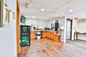 A kitchen with wooden cabinets, a refrigerator, a microwave, and a coffee machine.