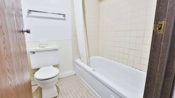 Une salle de bain comprenant des toilettes, une baignoire et une douche.