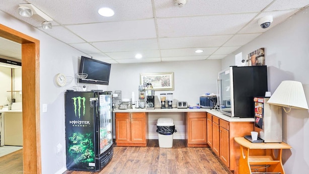 A compact kitchen with a refrigerator, microwave, coffee maker, and a TV mounted on the wall. - Pipestone|Queen Bed|Nsmk (Pipestone)