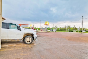 A parking lot with a white truck, a McDonald's sign, and a building in the background.