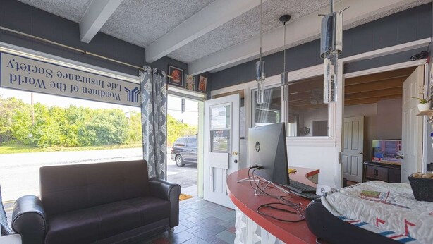 Een kamer met een bank, een bureau met een computer en een bed.