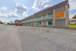 Ein Motel mit Balkon im zweiten Stock, ein Schild mit der Aufschrift Sunrise Inn und ein Lkw vor der Fassade.