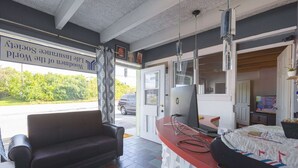 A room with a sofa, a desk with a computer, and a bed.