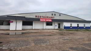 A restaurant building with a 'NOW OPEN' sign. - King Bed|Non-Smoking (Quinter)