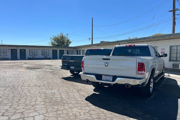 A parking lot with two trucks, a building with multiple doors, and overhead power lines.