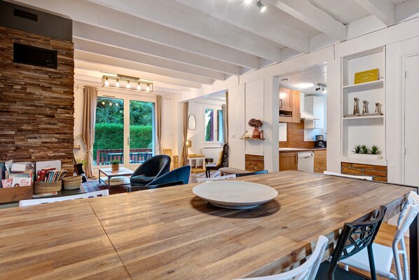 A modern kitchen with white cabinets, a wooden countertop, and a built-in oven.