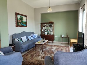 Ein Wohnzimmer mit einer Couch, einem Couchtisch, einem Schrank und einem Fernseher.