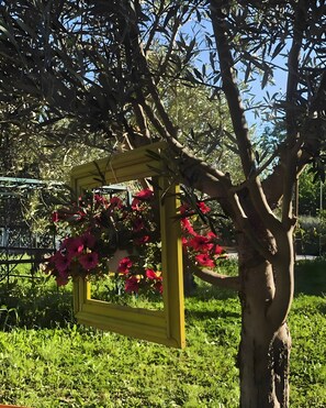 Ein Baum mit einer gelben Rahmenstruktur, die rote Blüten trägt.