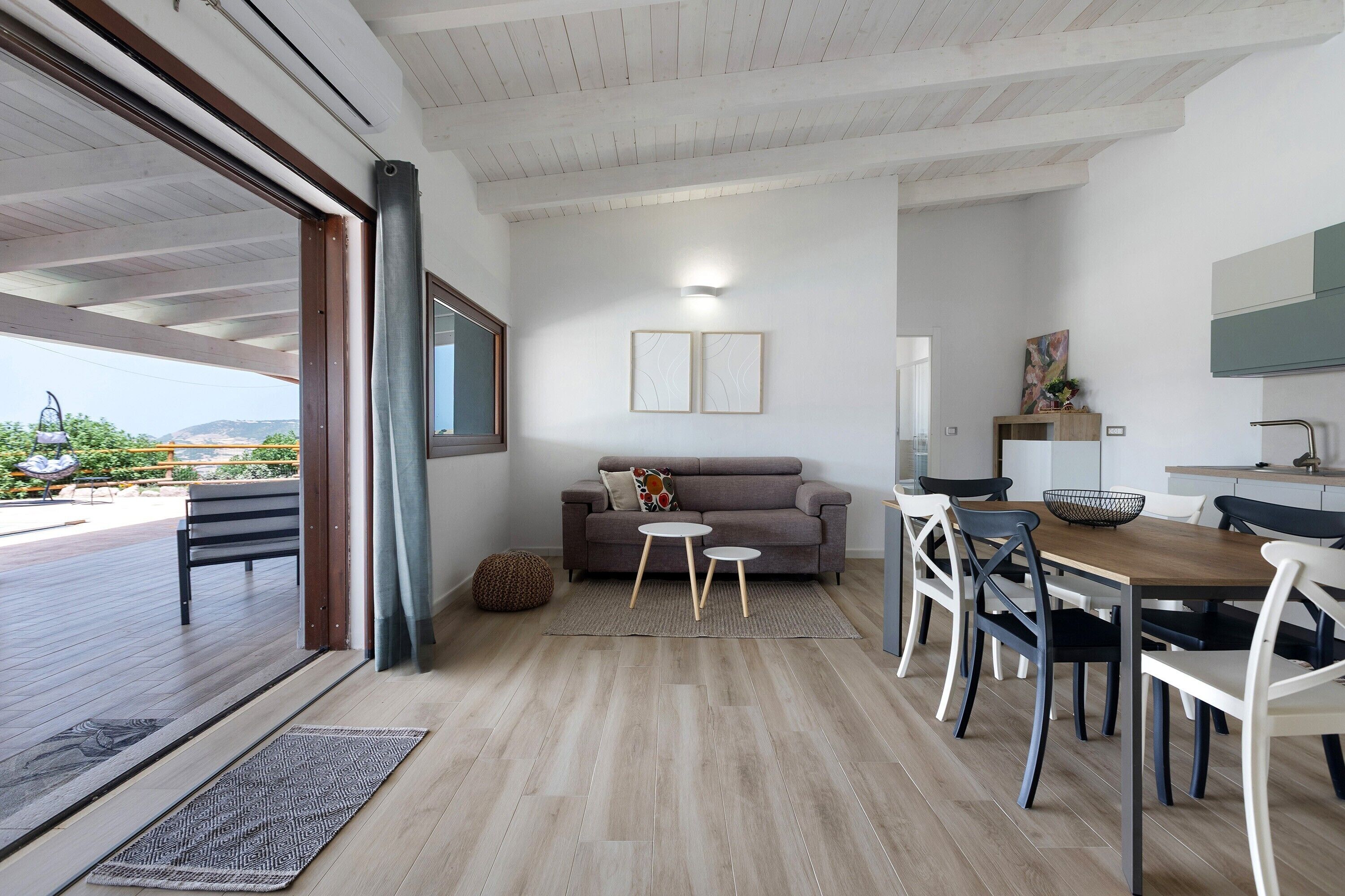 A modern living room with a sofa, coffee table, and dining area.