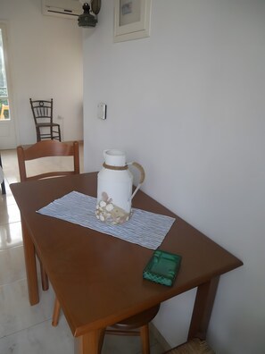 A dining table with a white pitcher, a placemat, and a green napkin.