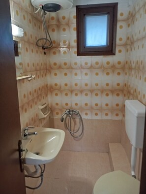 Un baño con lavamanos, inodoro, ducha y ventana.