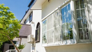 A building with large windows and a tree in front. - PENSION SERENADE (Hakuba)