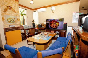 Una sala de estar con un sofá, una mesa de centro, un televisor y una chimenea.