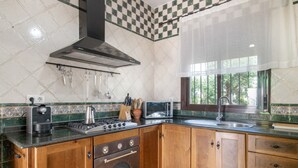 Una cucina con piano cottura, forno e microonde.