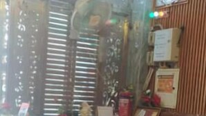 A room with a reception desk, a bed, a television, and a chandelier. - Hotel Ganpati (Ayodhya)
