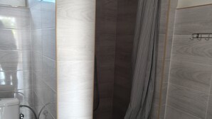 Un baño con ducha, inodoro y lavabo.