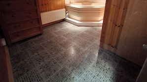 A wooden interior with a corner bathtub, a radiator, and a wooden cabinet. - Worcester Haven - Charming Sunderland House (Sunderland)