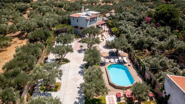 Ett flygbildsfoto av en fastighet med en swimmingpool, en uteplats och en liten byggnad.