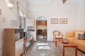 Un espacio habitable compacto con kitchenette, comedor y sofá.