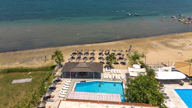 A resort with a swimming pool, beach area, and ocean view.