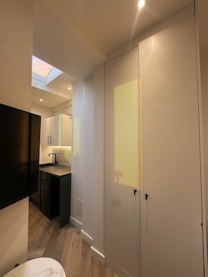 A modern interior with a skylight, a kitchen area, and a wardrobe.