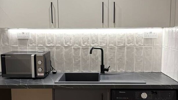 A compact kitchen with a microwave, sink, and dishwasher. - Studio, West Kensington + Hammersmith (Greater London)