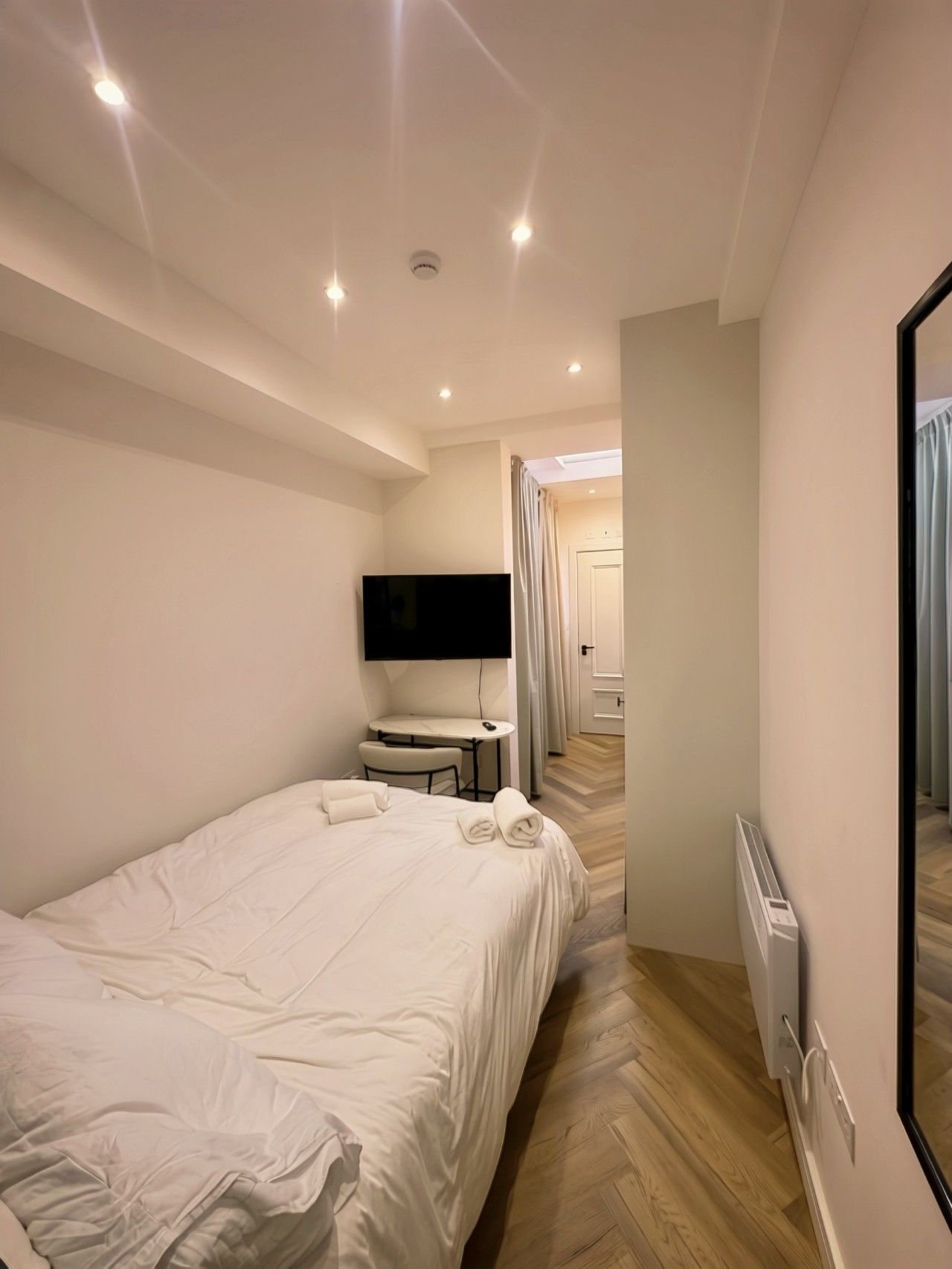Une chambre d’hôtel équipée d’un lit, d’un téléviseur à écran plat, d’une petite table et d’une chaise.