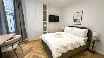 Escritorio, tabla de planchar con plancha, wifi y ropa de cama
