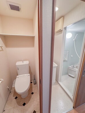 Ein kleines Badezimmer mit Toilette, Duschbereich und Waschbecken.