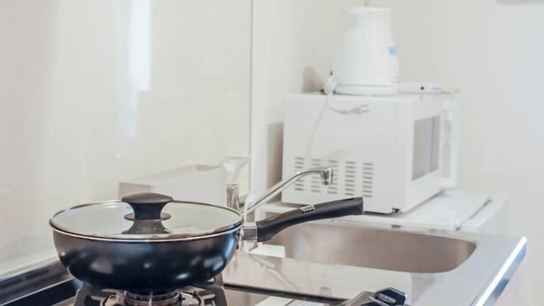 A kitchen with a stove, a sink, and a microwave. - GrandPacific Ebisuhonmachi (Osaka)
