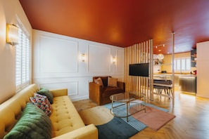 Ein modernes Wohnzimmer mit einer Couch, einem Couchtisch und einem Fernseher.