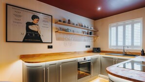 Una cocina moderna con electrodomésticos integrados, encimeras de madera y una vinoteca.