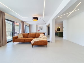 Ein modernes Wohnzimmer mit Ecksofa, Essbereich und Küche.