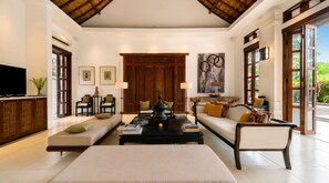 A spacious living area with a sofa, chairs, a coffee table, and a television. - Villa V Seminyak (Badung)