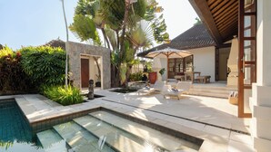 A pool area with steps leading to a patio with outdoor furniture and a covered seating area. - Villa V Seminyak (Badung)