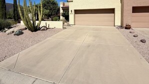 A residential property with a garage, a driveway, and a cactus in the landscaping.