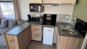 A compact kitchen with a microwave, coffee maker, toaster, and dishwasher.