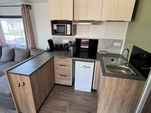 A compact kitchen with a microwave, coffee maker, toaster, and dishwasher. - Cozy family chalet near a recreational lake, forest, and hiking trails (Gasselte)