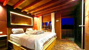A wooden-framed bedroom with a bed, a nightstand, and a view of the outside.