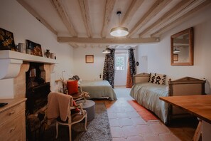 A cozy room with a fireplace, a bed, a desk, and a mirror.