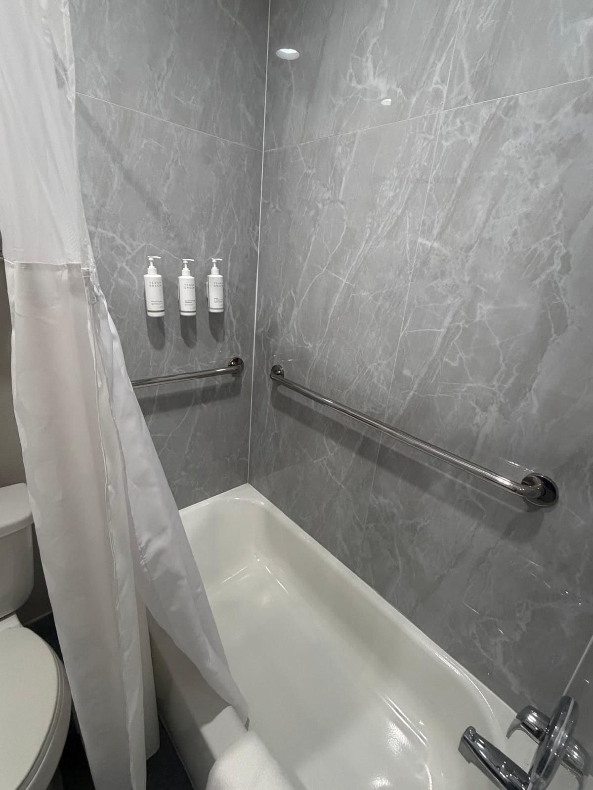 Un baño con bañera, inodoro y zona de ducha.