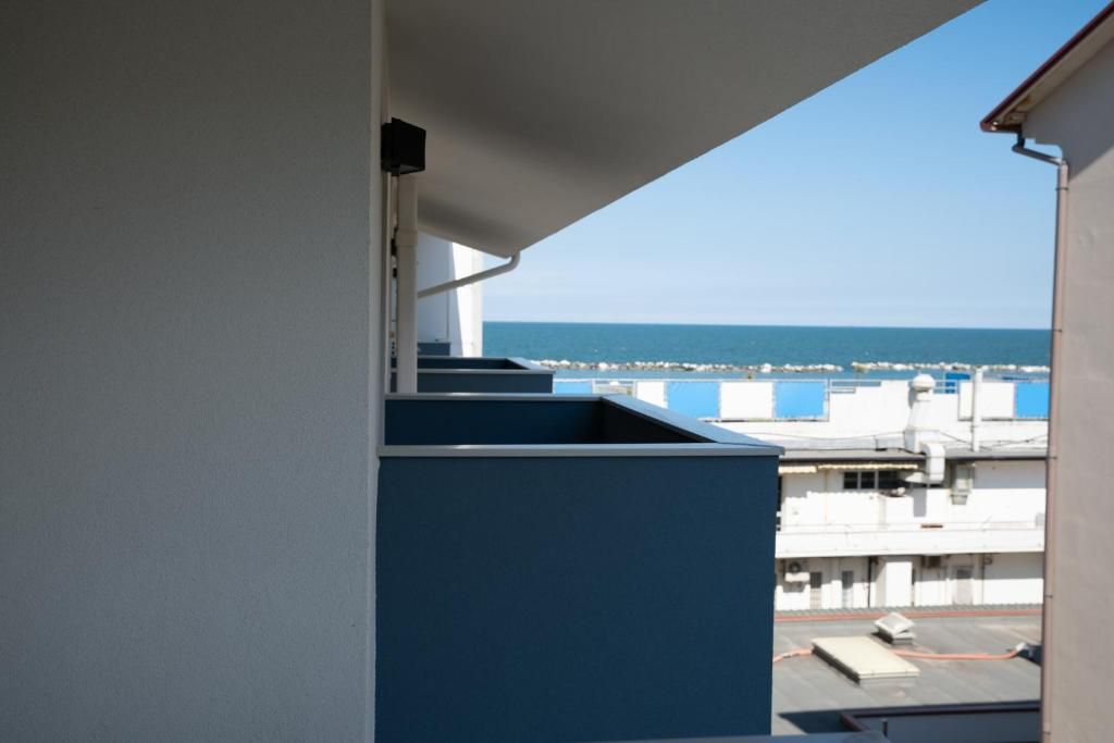 Ein Balkon mit Blick auf das Meer und Gebäude im Hintergrund.