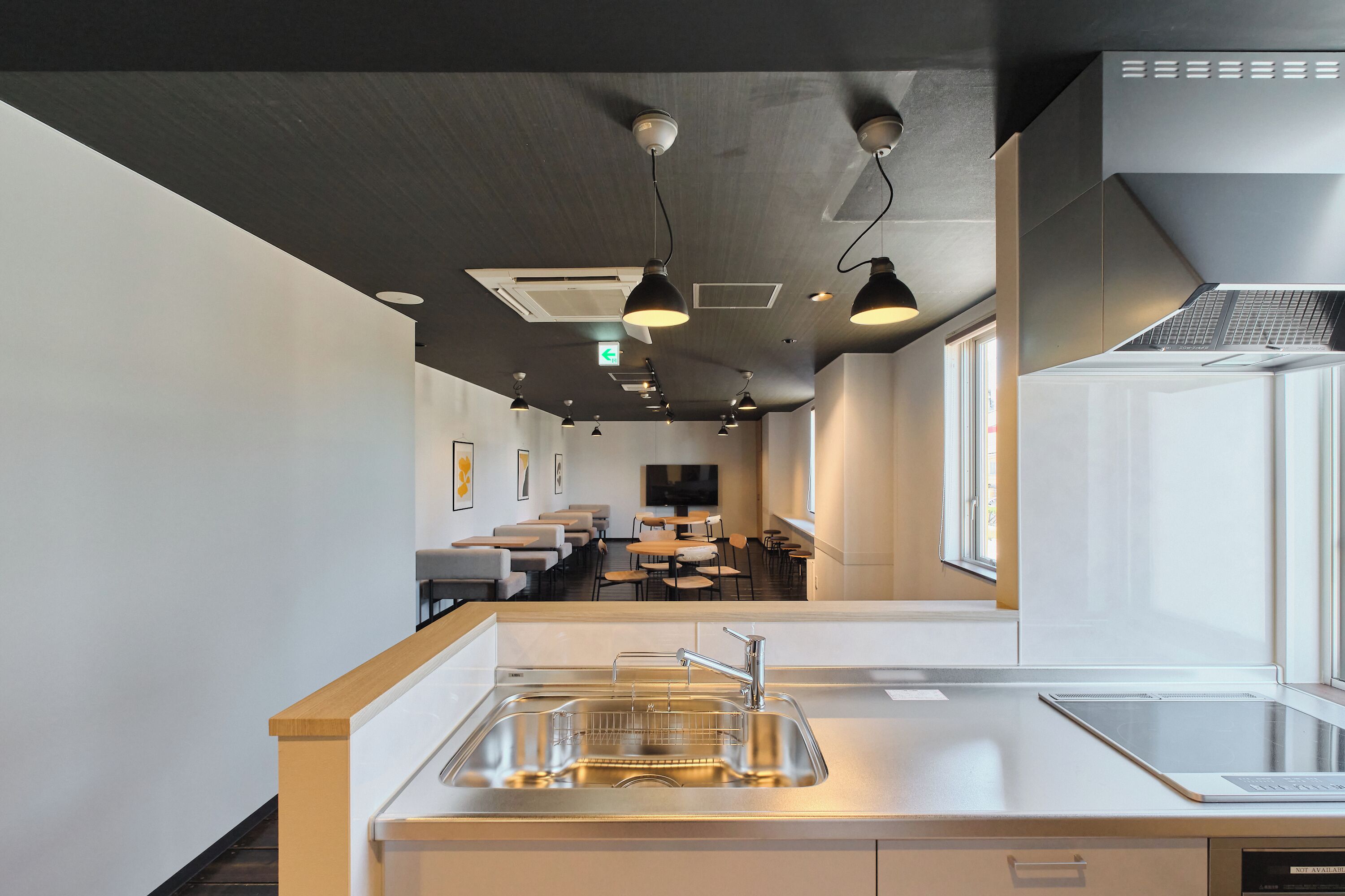 A modern kitchen with a stainless steel sink, a built-in oven, and a window providing natural light.