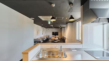 A modern kitchen with a stainless steel sink, a built-in oven, and a window providing natural light.