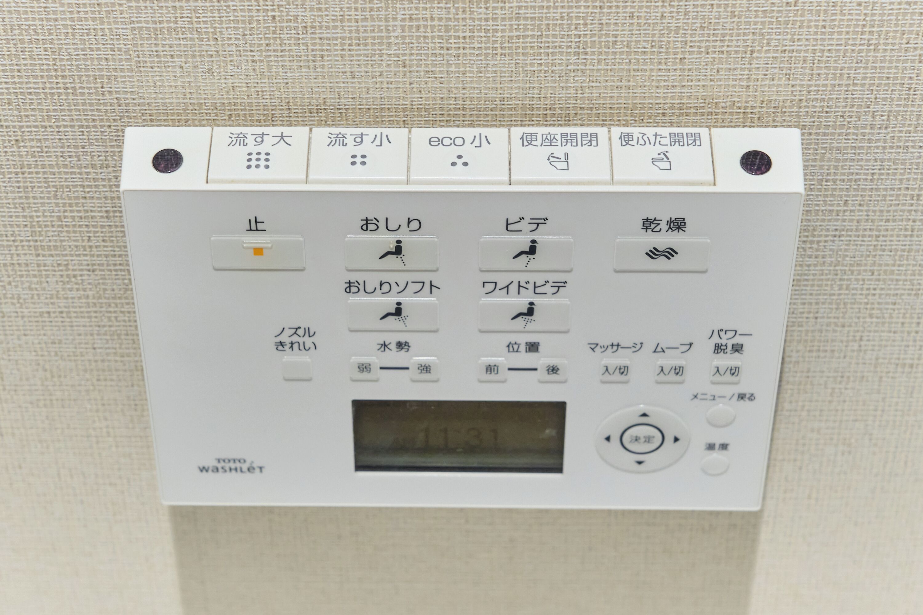 Panel de control con texto y símbolos japoneses, incluyendo una pantalla digital.