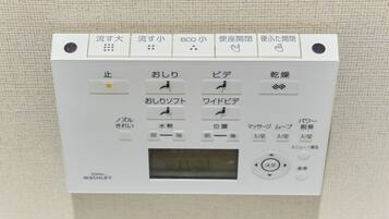 Panel de control con texto y símbolos japoneses, incluyendo una pantalla digital.