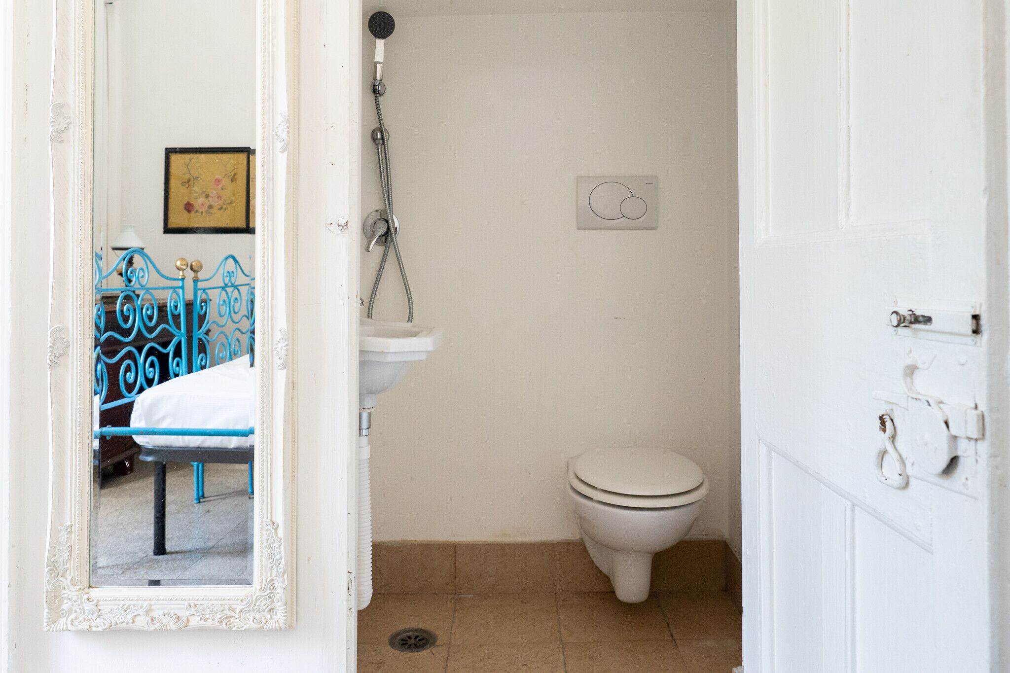 A bathroom with a white toilet, a sink, and a shower.
