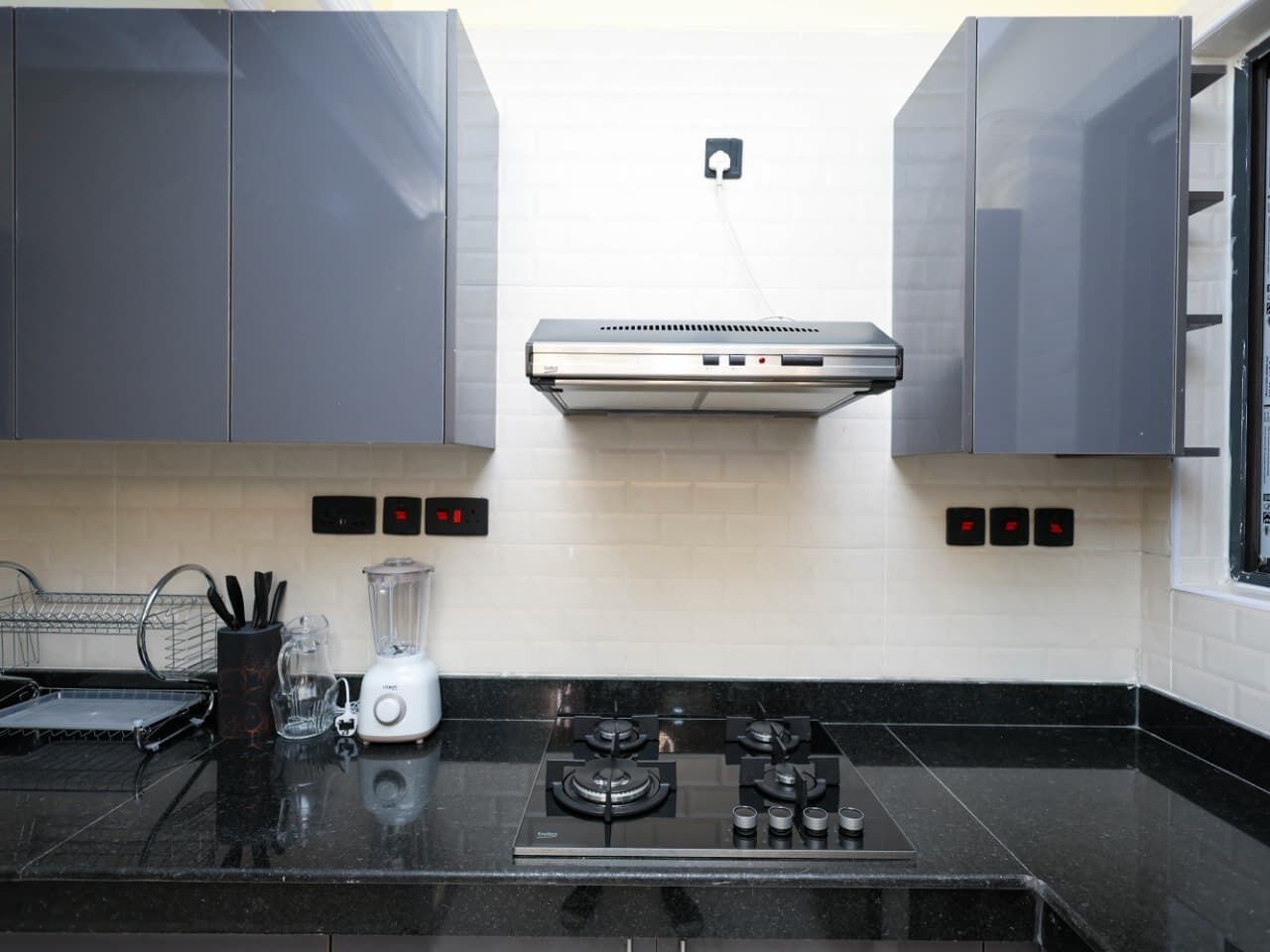 A modern kitchen with a gas stove, a blender, and a toaster.
