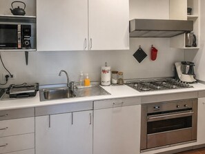 Eine moderne Küche mit Mikrowelle, Toaster, Spüle, Herd und Backofen.