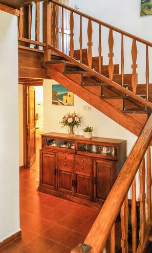 A wooden staircase with a railing, a cabinet with glass doors, and a painting on the wall. - Il Casale dei Castagni (Caprarola)
